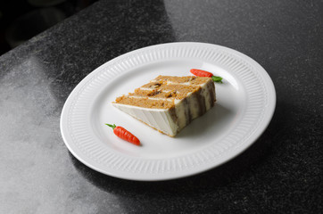 Carrot cake on a white plate decorated with carrots