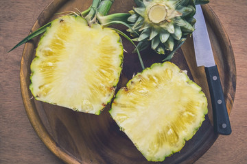 Fresh Pineapple cutting in wood plate on wooden table