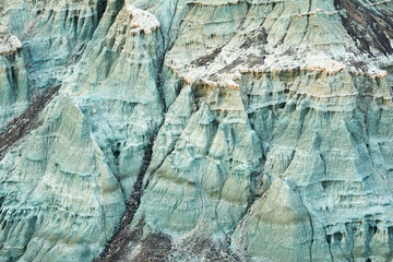 Sunset surrealistic landscape in John Day Fossil Beds National Monument Blue Basin area with grey-blue badlands. A branched ravine and Heavily eroded formations.