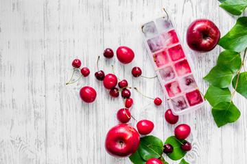 Apple, pulm, cherry, ice for summer fruit drink on wooden table background top view copyspace