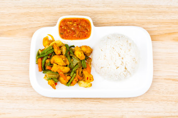 Isolated Asian cuisine fried chicken with turmeric, onion, long bean, carrot and chili spicy sauce with steam rice 