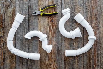 Clear clogged sink drains. Parts and tools on wooden background top view