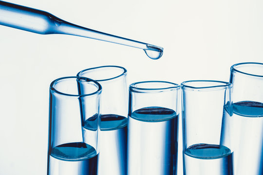 Chemistry background. Isolated test tubes filled with transparent fluid.