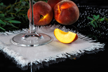 peaches lie on a beautifully laid table with black glass