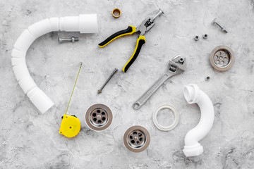 Plumber tools on grey stone background top view