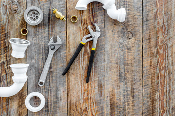 Plumber tools on wooden background top view copyspace