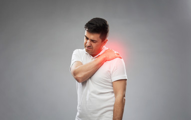 unhappy man suffering from pain in shoulder