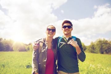 happy couple with backpacks hiking outdoors