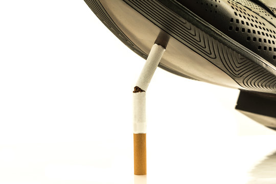 No tobacco. The sole of a black boot crushes a cigarette