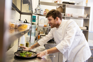 happy male chef cooking food at restaurant kitchen