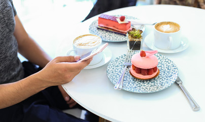 Man Holding Smartphone Texting Waiting for a Date at the Coffee Shop with Cup and Dessert