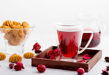 The cup with double glass with hibiscus tea is on a table.