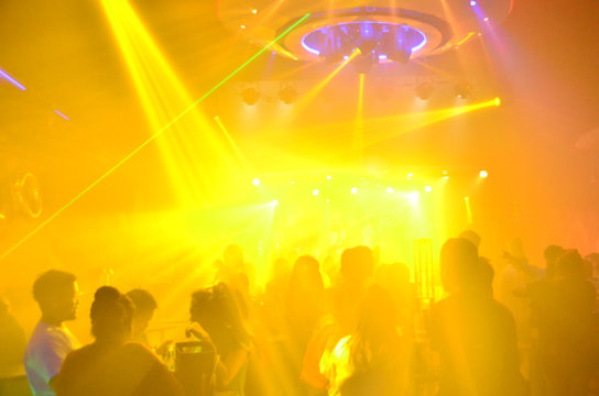 club party is blurred for background.Light in club party Show And Silhouette hands enjoying the club party with concert. Blurry night club DJ party people enjoy of music dancing sound .