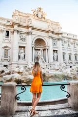 Papier Peint photo Rome Fille en robe jaune devant la fontaine de Trevi, Rome, Italie. Jeune jolie fille aux cheveux blonds dans une robe jaune. Shooting photo à Rome, Italie