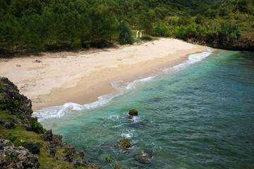 perfect destination for vacation - small tropical bay with bright sand, and a dirty road