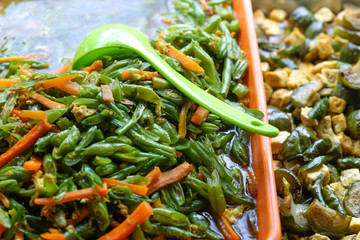we should eat more vegetables - green plastic spoon in javanese bean - carrot - tofu salad