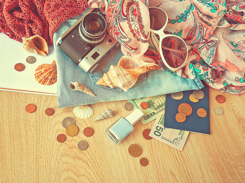 Preparation for a travel. Outfit of young woman. Different objects on wooden surface.