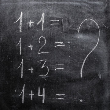 Arithmetic examples, written in chalk on old blackboard
