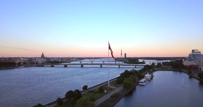Beautiful aerial sunset view over Riga in Latvia with Huge Latvian flag in the foreground and river Daugava around the damb.