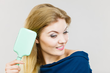 Woman brushing her long hair with brush