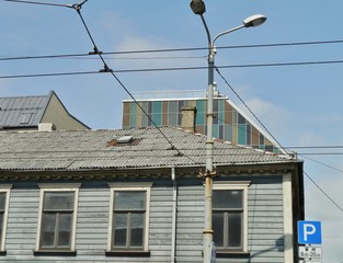 Holzhaus in Riga mit Neubau im Hintergrund