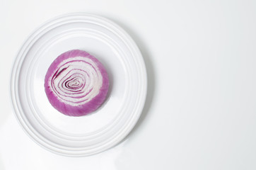onion cut in half on a white plate on a white background