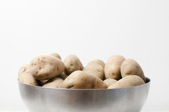 side view of a silver bowl with potatoes