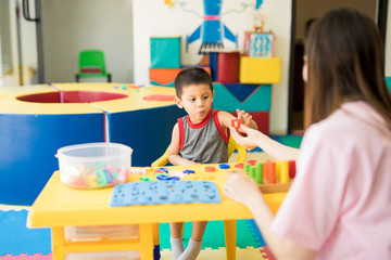 Little kid practicing pronunciation in language therapy center