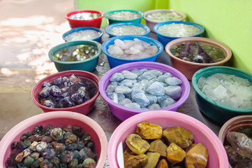 Various crude gems in a colorful baskets in a gemstone workshop