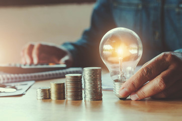 business accountin with saving money with hand holding lightbulb concept financial background