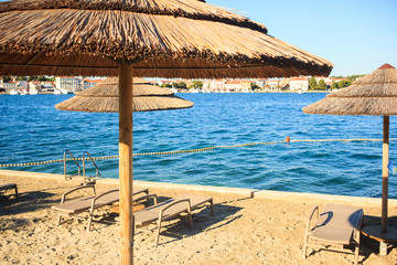 Beach umbrellas in Saint Nicholas island in Porec, Istria. Croatia
