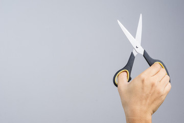 Hand holding office scissors