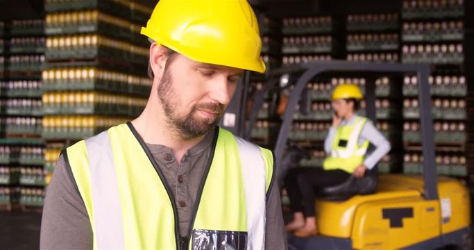 Male supervisor maintaining record on clipboard in warehouse