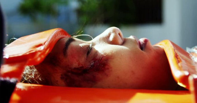 Paramedics examining injured African American girl