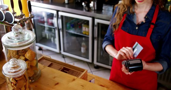 Waitress swiping credit card at counter
