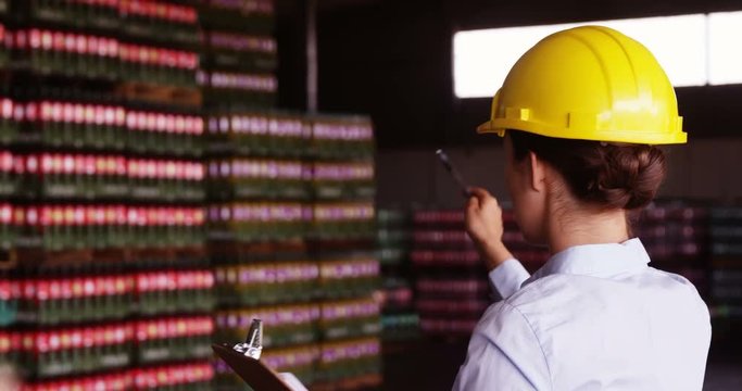 Female supervisor maintaining record on clipboard