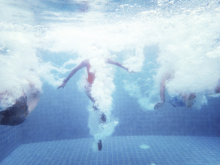 Group of people jumped down to the swimming pool underwater shot