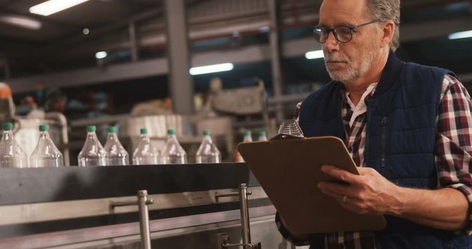 Male worker maintaining records on clipboard