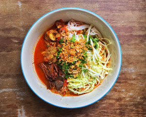 Northern Thai dish made from fermented rice noodles served with pork or chicken blood tofu in a sauce made with pork broth and tomato, crushed fried dry chilies, and dried red kapok flowers.
