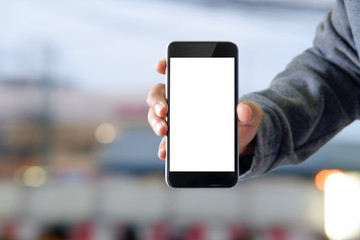 Man showing smartphone at abstract blurred street night. Blank screen for graphics display montage.