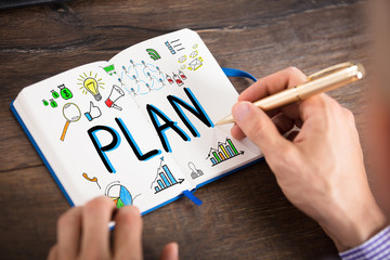 Businessperson Drawing The Plan Chart On Notebook