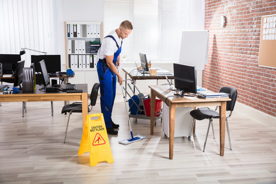 Male Janitor Cleaning Floor With Mop