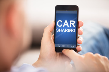 Man Using Car Sharing Application On Smart Phone