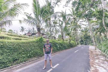 Fototapeta na wymiar Portrait of a traveler man in sunglasses in the tropical jungle of Bali island, Ubud, Indonesia.
