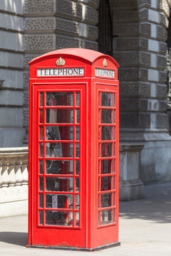 Red telephone booth on the street in the city, London, United Kingdom.