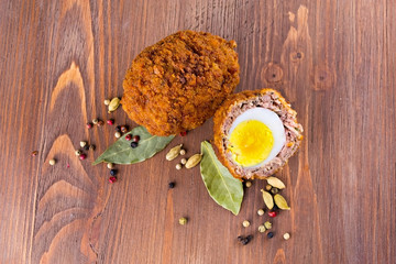 Scotch egg with spices on a wooden background
