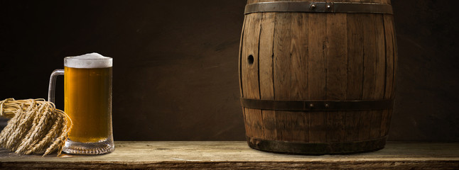 Beer barrel with beer glasses on table on wooden background