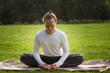 The yoga instructor in the lotus posture relaxes after exercising