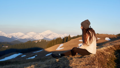 Shot of a woman admiring stunning view sitting on top of a mountain copyspace peace nature harmony lifestyle active sportive healthy relaxing resting meditative