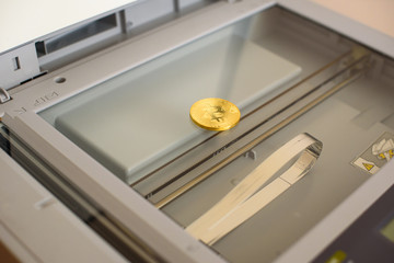 Physical bit coin. Digital currency. Golden bitcoin coin on a copier machine. The concept of...